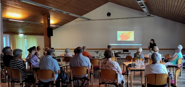 Foto zuhörende Ausstellungsbesucher und Impulsgeberin während des Vortrages